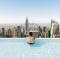Anak muda bersantai di kolam renang dengan pemandangan ke arah cakrawala Kota New York
