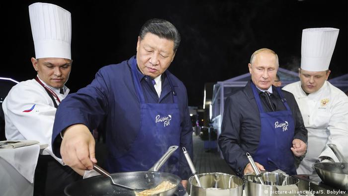 Vladivostok, September 2018: Presiden Xi dan Putin berdiri saat mereka menyiapkan makanan di forum ekonomi 